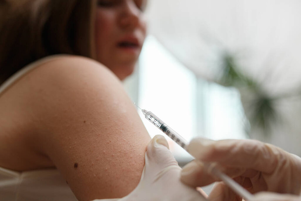 Η Πεδιάτρ εμβολιάζει ένα κοριτσάκι στο χέρι της.. - Φωτογραφία, εικόνα