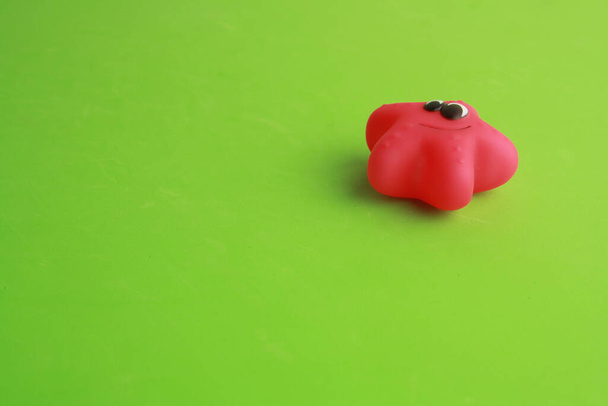 A closeup shot of a toy bathtub in a red starfish shape for children - Fotó, kép