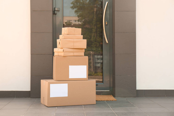 Cardboard boxes near door. Parcel delivery service - Фото, изображение