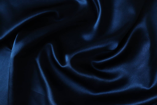 Smooth elegant dark blue silk or satin fabric. Draped luxury cloth texture for design. - Photo, Image