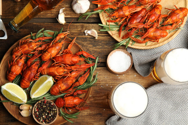 Flat lay composition with delicious red boiled crayfishes and beer on wooden table - Foto, Imagem