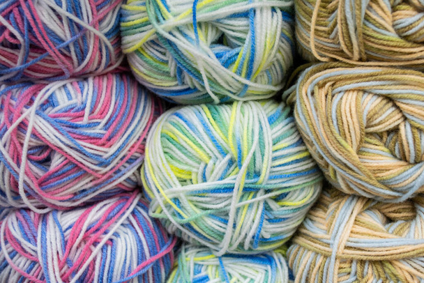 Primer plano de madejas de hilos variados mezclados colores pastel de blanco, azul, amarillo, verde y rosa. Hilos de fondo. - Foto, imagen