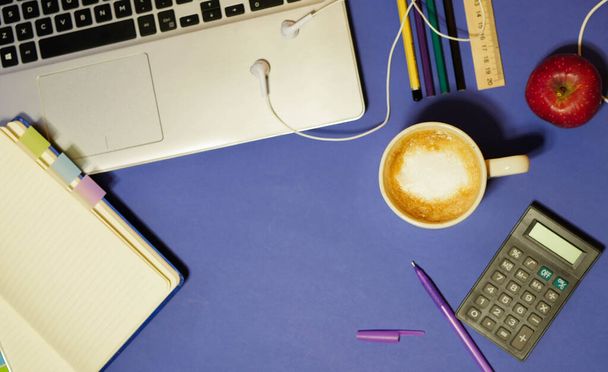 平置きだ。学生用机だ。ビジネススクール。オフィスの仕事の概念。古典的な青の背景。紙仕事だ。コーヒーを一杯。メモ帳と固定。フリーランスの職場 - 写真・画像