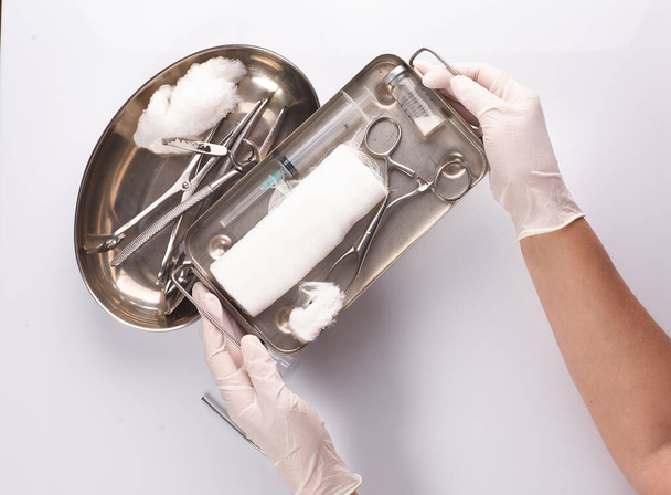 Οδοντιατρικές συσκευές σε αποστειρωμένη συσκευασία. Χέρι οδοντιάτρου σε γάντια - Φωτογραφία, εικόνα