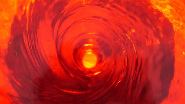 Symbool van de hel, inferno en oneindigheid. Rode vloeistof hypnotiserende lussen aqua werveling draaien. Meditatieve lichtgevende draaikolk. Mesmeriserende spiraalvormige tunnel van kristalvloeistof. Vurig surrealistisch ritmisch watergradiënt. - Foto, afbeelding