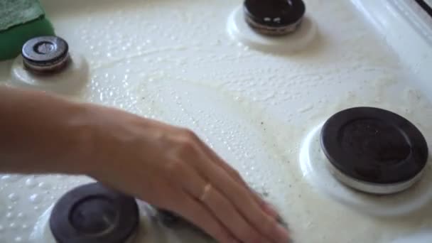 Sluit maar af. Hand in een handschoen op het fornuis, Afwassen van vuil niet van een keukenoppervlak. - Video