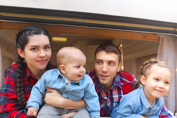 Portret uśmiechniętej szczęśliwej rodziny z dziećmi w domu na kółkach wewnątrz - Zdjęcie, obraz