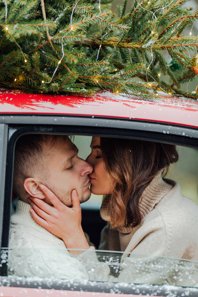 Winter love story of young couple, man and woman, christmas tree, outdoors - Fotografie, Obrázek