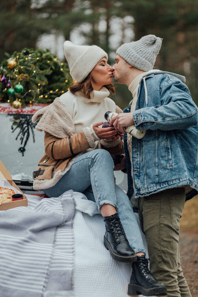 Winter love story of young couple, man and woman, christmas tree, outdoors - Fotó, kép
