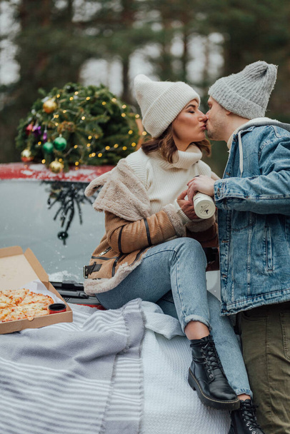 Historia de amor de invierno de pareja joven, hombre y mujer, árbol de Navidad, al aire libre - Foto, imagen