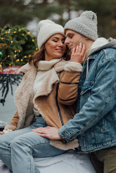 Winter love story of young couple, man and woman, christmas tree, outdoors - Фото, зображення