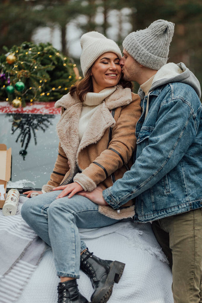 Winter love story of young couple, man and woman, christmas tree, outdoors - Valokuva, kuva