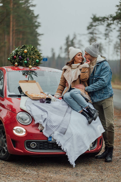 Winter love story of young couple, man and woman, christmas tree, outdoors - 写真・画像