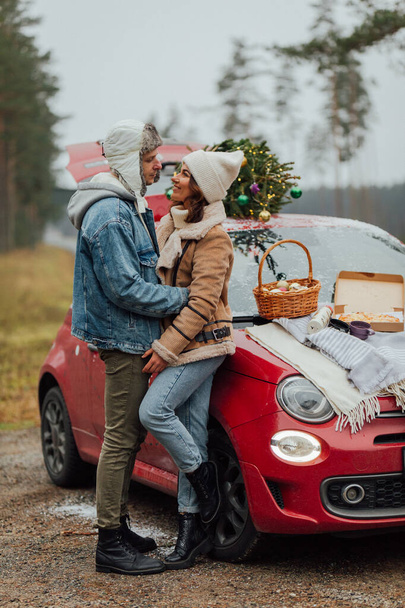 Winter love story of young couple, man and woman, christmas tree, outdoors - Foto, Bild
