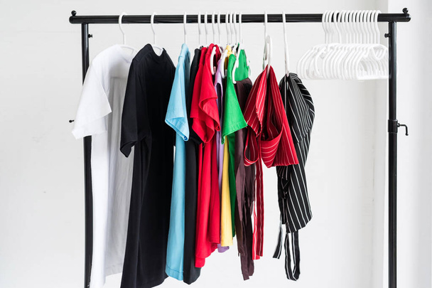 Limpe várias camisetas e roupas de avental penduradas no rack após a lavanderia. Higiene estilo de vida saudável e tarefas domésticas no conceito de fim de semana. - Foto, Imagem