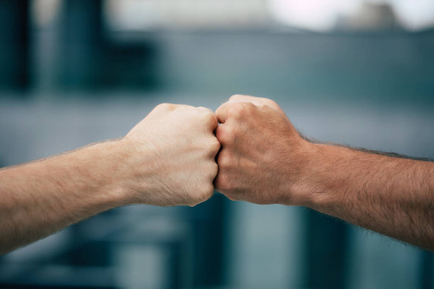Close up outdoor photo of two men's fists holding together - Fotografie, Obrázek