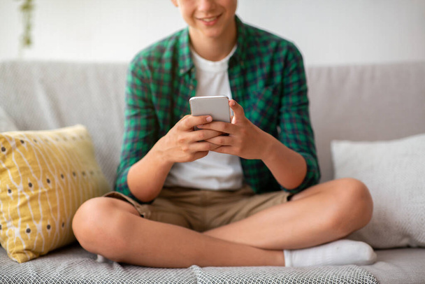 Обрізаний підліток за допомогою мобільного телефону вдома
 - Фото, зображення