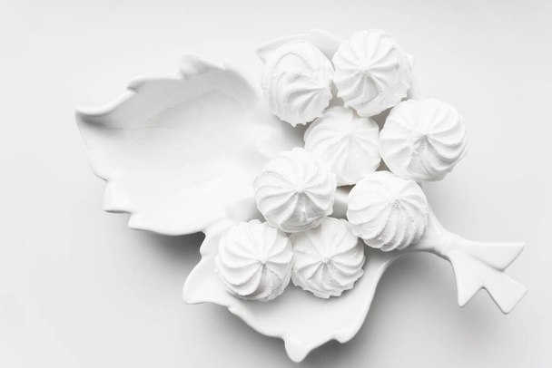 Meringues in white plate on a white background with copy space. - Foto, immagini