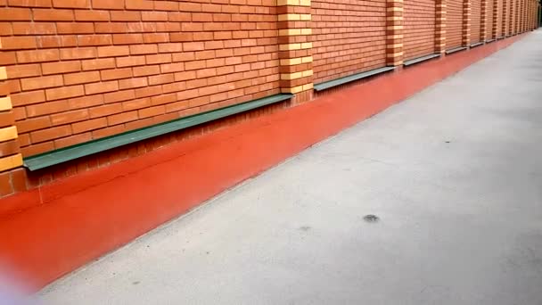Lassú kamera mozgás fel a téglafal, modern falazat, új narancssárga tégla, szabadban, 4k - Felvétel, videó