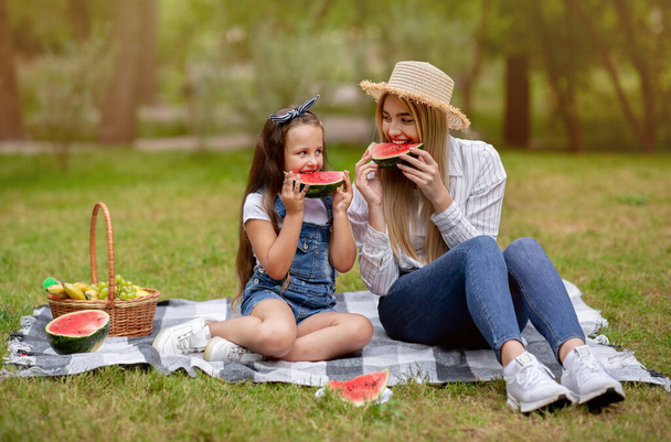 Mama i córka korzystające Piknik rodzinny Jedzenie arbuza w parku - Zdjęcie, obraz