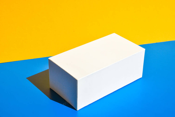 White box. Drugs box mock-up. Mockup. Copy space. Yellow and blue creative minimalism isometric background. Hard light. Shadows - Foto, imagen