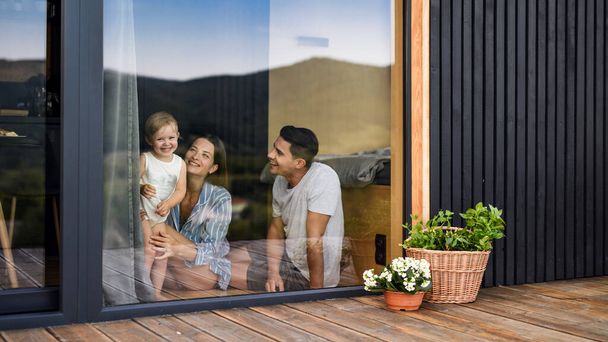Young family with small daughter indoors, weekend away in container house in countryside. - Photo, image