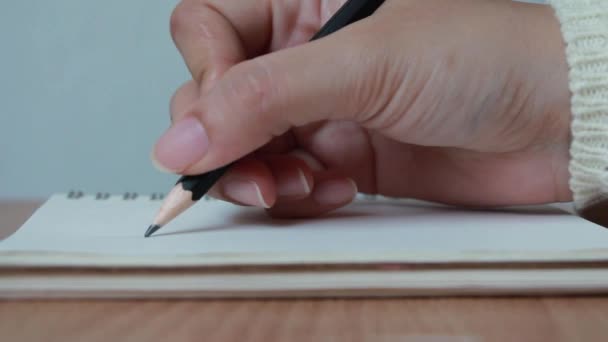Close-up hand trek een lijn op notebook. - Video