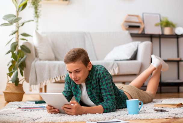 Schooler using digital tablet while studying at home - Fotografie, Obrázek
