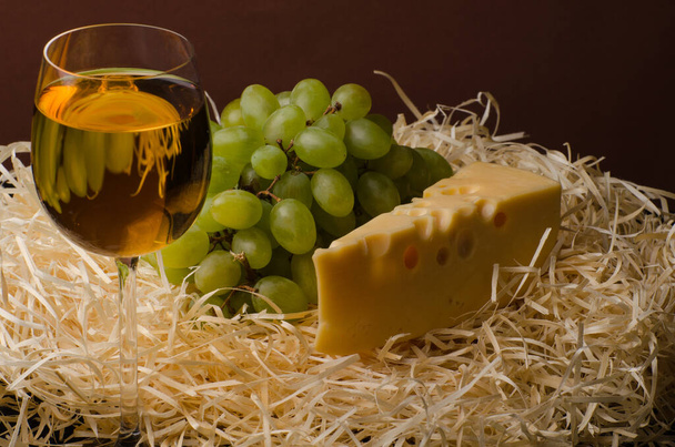 Ένα ποτήρι λευκό κρασί με τυρί και σταφύλια. Νεκρή ζωή - Φωτογραφία, εικόνα