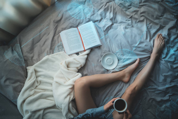 bella donna bruna nel letto del mattino con libri e caffè - Foto, immagini