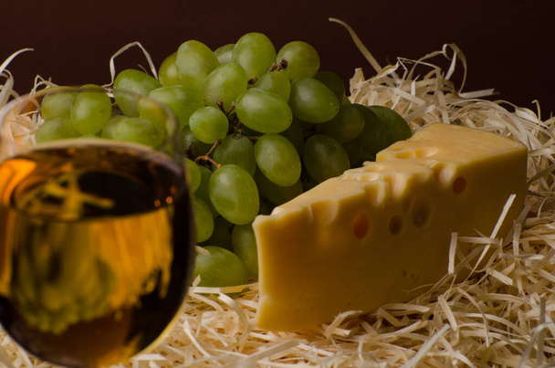 Una copa de vino blanco con queso y uvas. Bodegón - Foto, imagen