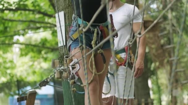 Adventure climbing high wire park - people on course in mountain helmet and safety equipment - Footage, Video