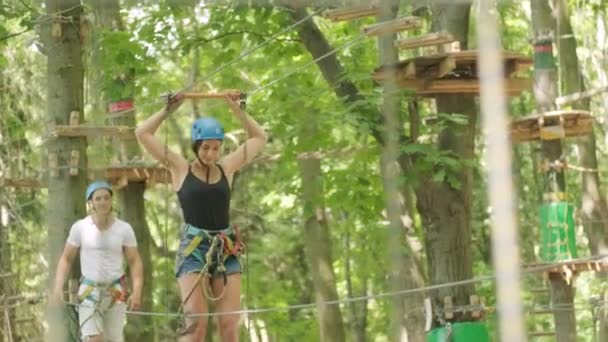 Seikkailu kiipeily korkea lanka puisto - ihmiset kurssilla vuoren kypärä ja turvalaitteet - Materiaali, video