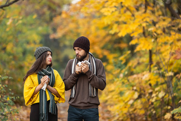 病気の男と女が公園で秋に鼻を吹いて. - 写真・画像