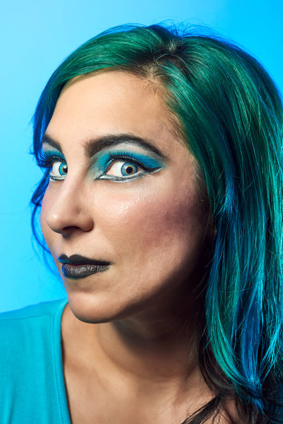Close-up of a girl with blue hair on a blue background. Beauty and fashion concept - Photo, Image