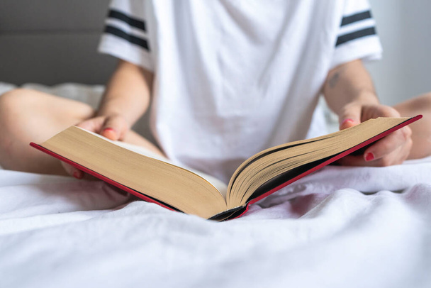 Женщина, читающая книгу в постели - Фото, изображение