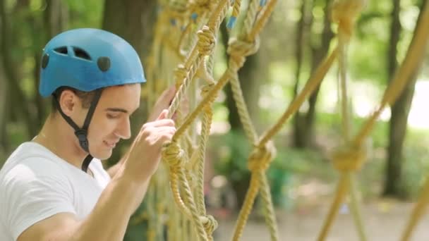 Adventure climbing high wire park - Człowiek na kursie w hełmie górskim i sprzęt bezpieczeństwa - Materiał filmowy, wideo