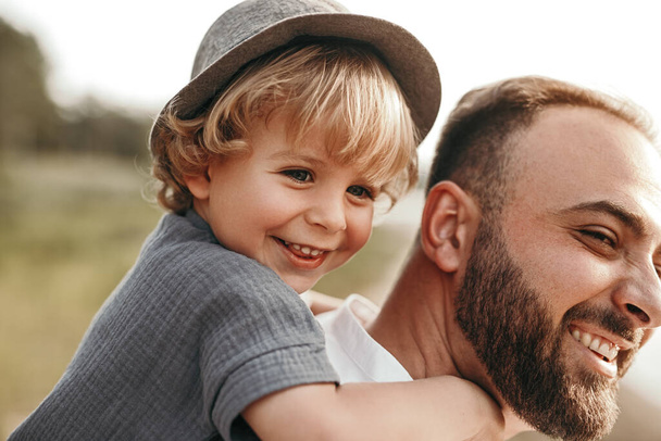 Bearded father giving piggyback ride to son - Photo, image
