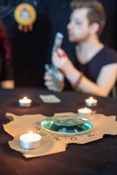 Cajero de la fortuna usando cartas del tarot sobre fondo negro - Foto, Imagen