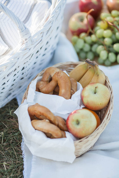 Picnic. Fruta en una cesta, una manta, productos horneados en una cesta en la naturaleza. - Foto, imagen