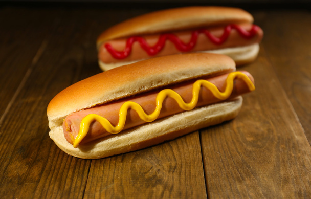 Tasty hot dogs on wooden table - Foto, Imagen