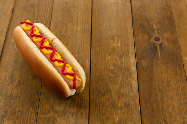 Tasty hot dog on wooden table - Fotoğraf, Görsel