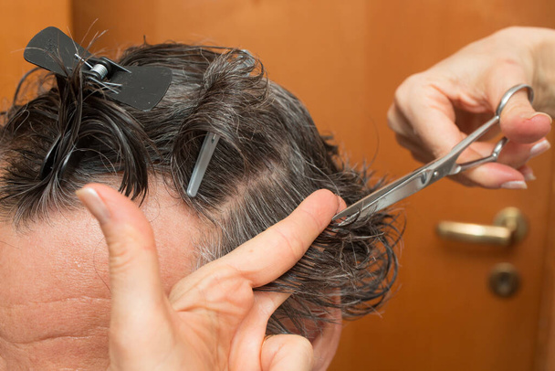 Homme âgé se faire couper les cheveux à la maison.  - Photo, image
