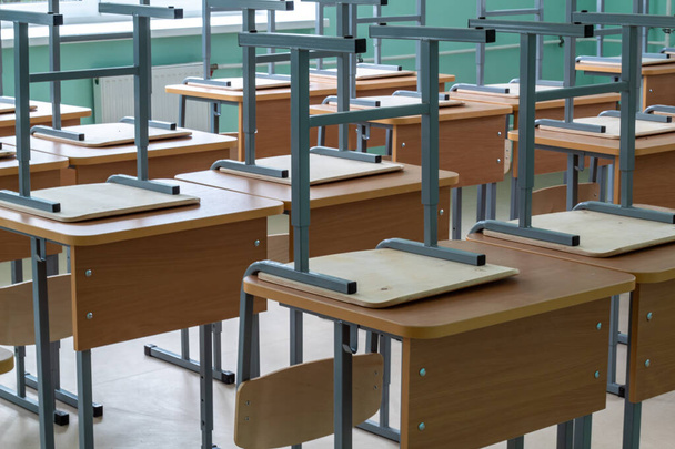 Empty classroom, inverted chairs on desks, distance learning during the pandemic. - 写真・画像