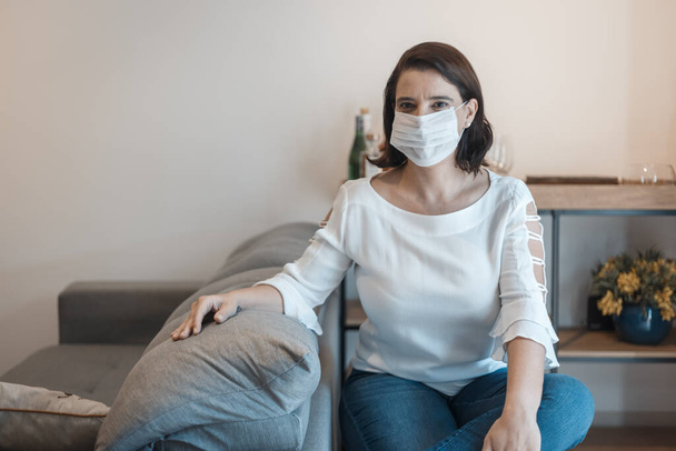 young woman at home wearing coronavirus protection mask (covid 19) - Foto, immagini