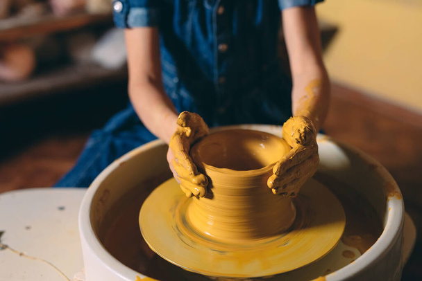 Pottery workshop. A little girl makes a vase of clay. Clay modeling - Fotografie, Obrázek