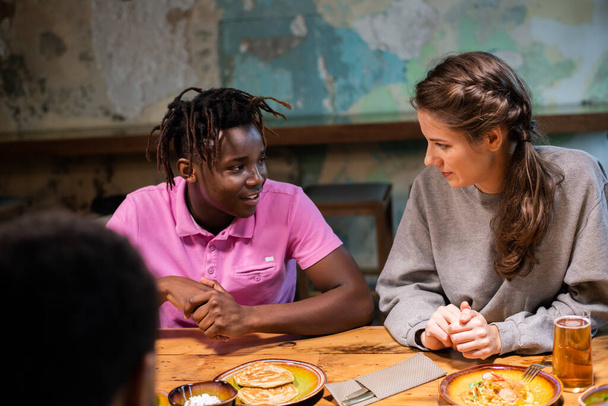 A multi-ethnic friends chatting in a modern cafe - Zdjęcie, obraz