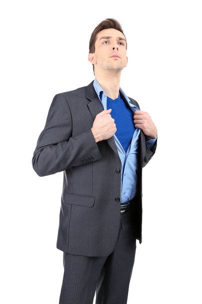 Young business man tearing apart his shirt revealing superhero suit, isolated on white - Foto, Imagem