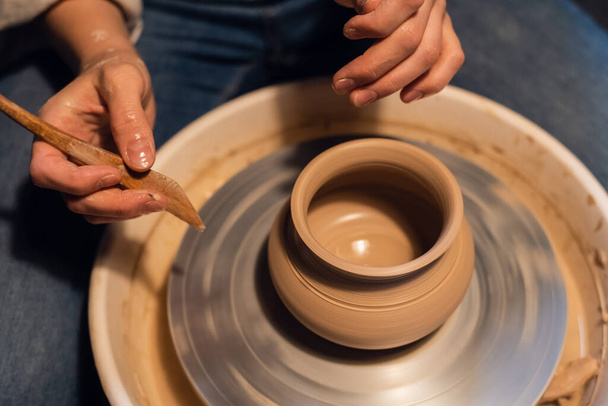 belas mãos de uma jovem oleiro no processo de esculpir um vaso com argila e ferramentas. - Foto, Imagem