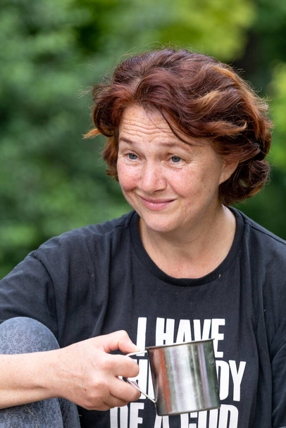 Portrait of a woman in a black T-shirt with the inscription on a green background - Photo, Image